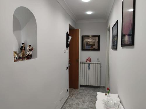 einen Flur mit weißen Wänden und eine Tür mit Figuren in der Unterkunft GevyNapule in Neapel