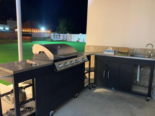 a kitchen with a grill and a field at night at Labella Chalet in Barka