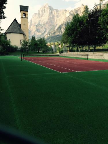 a tennis court with a mountain in the background at TH Borca di Cadore - Park Hotel Des Dolomites in Borca di Cadore