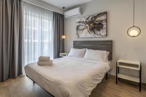 a bedroom with a large white bed in a room at Studio 21 with kitchenette at the new Olo living in Paceville