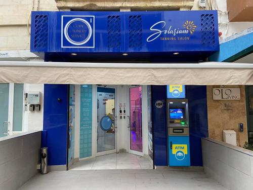 a building with a ticket machine in front of a store at Studio 21 with kitchenette at the new Olo living in Paceville