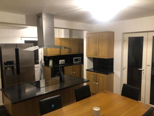 a kitchen with wooden cabinets and a wooden table with a counter top at Cozzy Living in Killingbeck