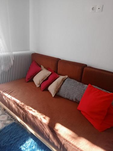 ein braunes Sofa mit vier Kissen darauf in der Unterkunft Σαν Παραμυθάκι in Filýra