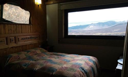 1 dormitorio con cama y ventana grande en Apartamento Rural El Herrero vistas espectaculares a Gredos, en Cabezas Bajas