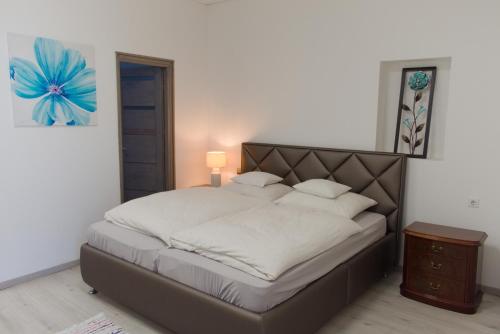 a bedroom with a large bed with a blue flower on the wall at Silver Dream Apartman in Debrecen