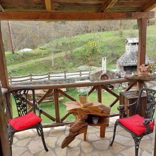 eine Veranda mit zwei Stühlen und einem Tisch und einer Aussicht in der Unterkunft Σαν Παραμυθάκι in Filýra