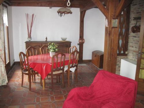 ein Esszimmer mit einem roten Tisch und Stühlen in der Unterkunft Le Clos D'aval Le Paulownia in Saint-Nicolas-dʼAliermont