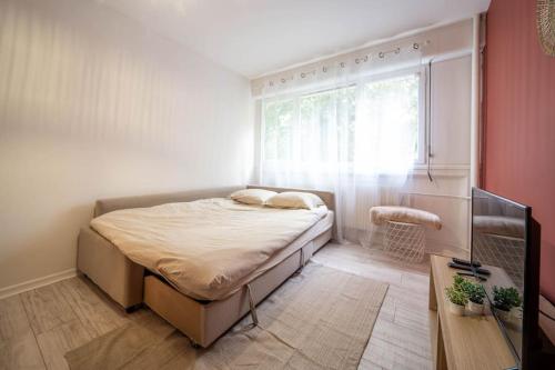 um pequeno quarto com uma cama e uma janela em L'escale mauricienne em Chalon-sur-Saône