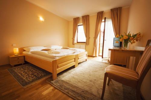 1 dormitorio con 1 cama y 1 silla en Hotel Karpatsky Dvor, en Lozorno