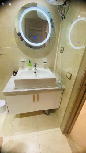 a bathroom with a white sink and a mirror at Résidence avec piscine Agadir in Agadir