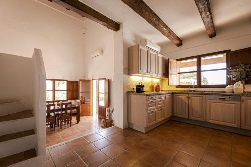a kitchen with wooden cabinets and a dining room at CAN NOVES - Villas de 4 suites 52 y 35 in Sant Francesc Xavier