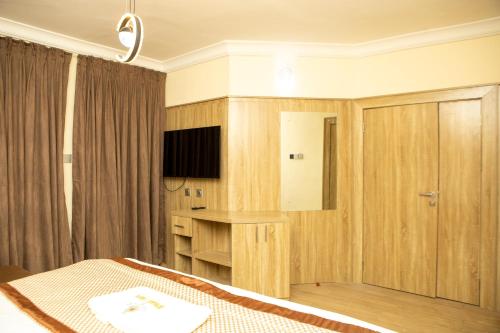 a hotel room with a bed and a television at Wingate Exotic in Ilorin