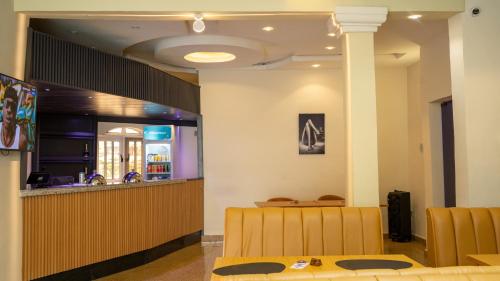 a restaurant with a table and chairs and a bar at Wingate Exotic in Ilorin