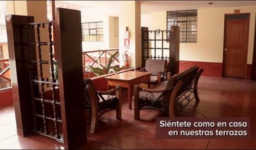 ChalhuancaにあるHOTEL ZEGARRAの木製のテーブルと椅子、テーブルと椅子が備わる客室です。