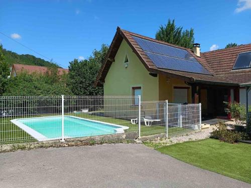 une clôture autour d'une piscine en face d'une maison dans l'établissement Maison de campagne avec piscine, à Courbouzon