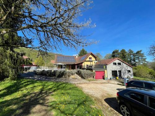 a house with a car parked in front of it at Maison de campagne avec piscine in Courbouzon