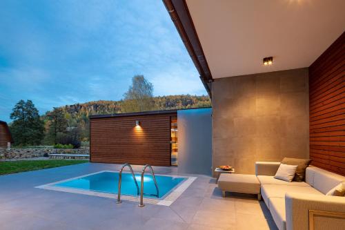 a swimming pool in a patio with a couch and a couch at Hotel Ostrov in Tisá