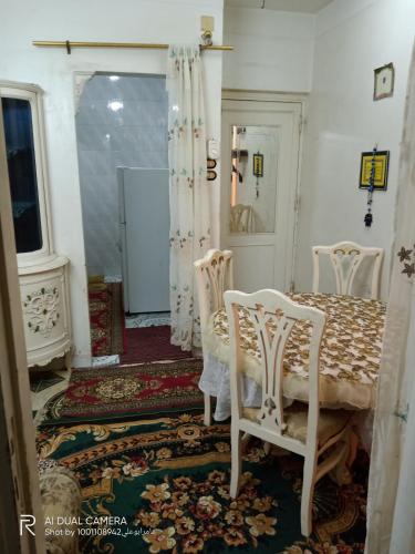 a dining room with a table and two chairs at شقة مفروشة للايجار بدمياط القديمة in Dumyāţ