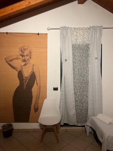 a painting of a woman in a black dress on a wall at Affittacamere Karma Rho-Fiera in Rho