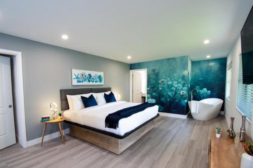 a bedroom with a large bed and a bath tub at The Lauderdale Boutique Hotel in Fort Lauderdale