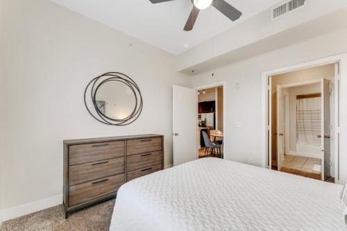 een slaapkamer met een groot bed en een spiegel bij Beautiful 1br Apartment, Pool, Gym, Parking Cs in Dallas