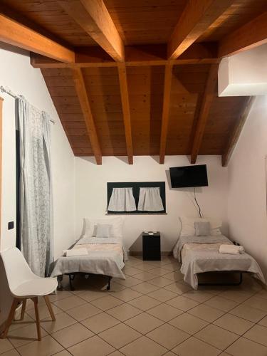 a room with two beds and a tv on the wall at Affittacamere Karma in Rho