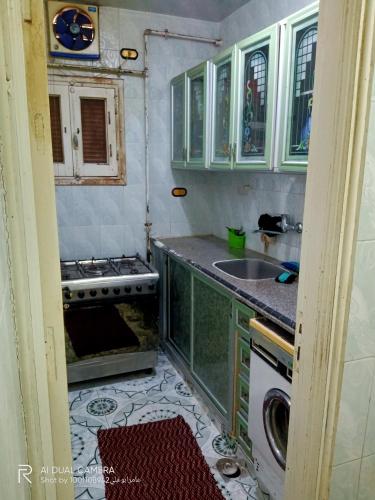 a kitchen with green cabinets and a sink and a stove at شقة مفروشة للايجار بدمياط القديمة in Dumyāţ