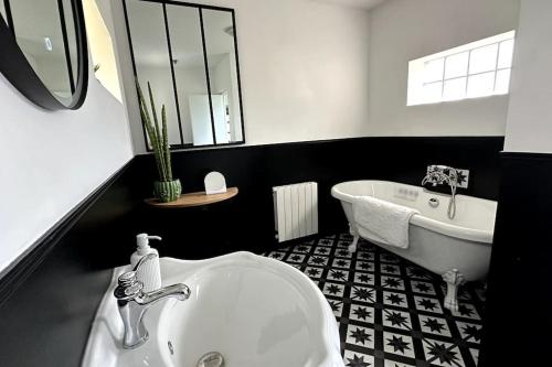a black and white bathroom with a tub and a sink at Agréable maison de ville 