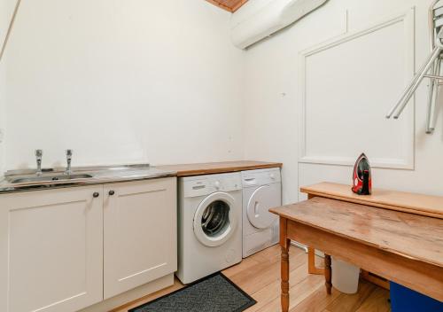 a kitchen with a washing machine and a sink at The Counting House in Fowey