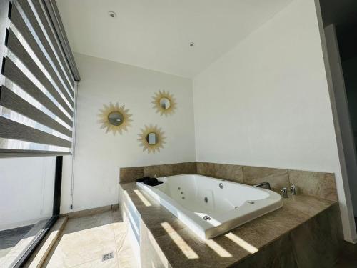y baño con bañera y 2 espejos en la pared. en Hotel La Mansión, en San José Iturbide