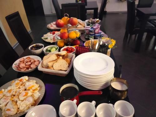 a table topped with plates and bowls of food at Hotel ENZO in Voluntari