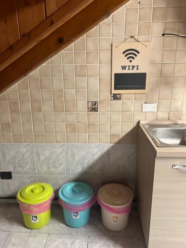 three trash buckets in a kitchen with a sink at Affittacamere Karma Rho-Fiera in Rho