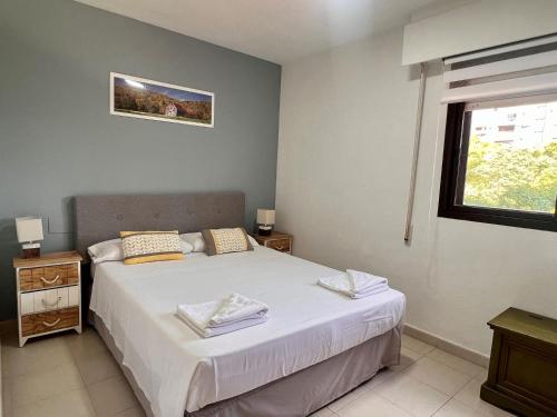 1 dormitorio con cama blanca y ventana en Friendly Flat, en Alicante