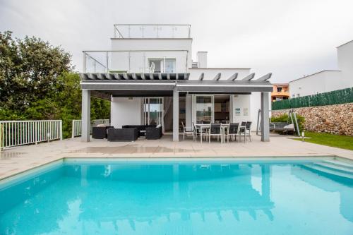 een huis met een zwembad en een patio bij Luxury Villa - Amazing Sea Views in Son Bou