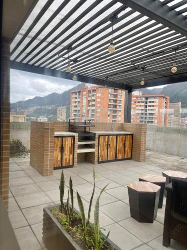 a rooftop patio with a view of a city at Mitika Cultura movilidad y tranquilidad in Bogotá