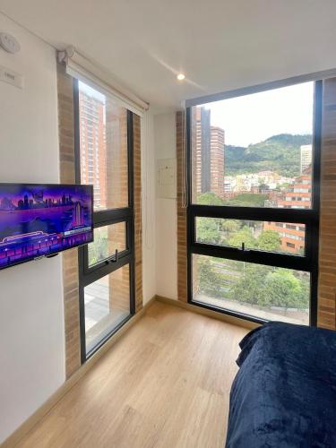 a bedroom with a bed and a large window at Mitika Cultura movilidad y tranquilidad in Bogotá