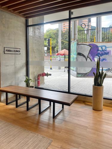 a wooden bench sitting in front of a large window at Mitika Cultura movilidad y tranquilidad in Bogotá