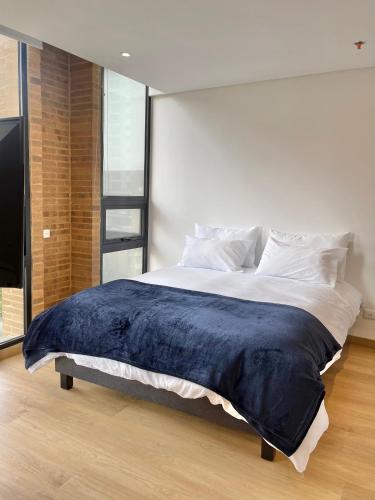 a bedroom with a large bed with a blue blanket at Mitika Cultura movilidad y tranquilidad in Bogotá