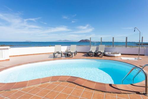 basen z widokiem na ocean w obiekcie Corralejo Beachfront Villa Remos with Lobos Island View, Private Pool, Wifi & BBQ by Amazzzing Travel w Corralejo