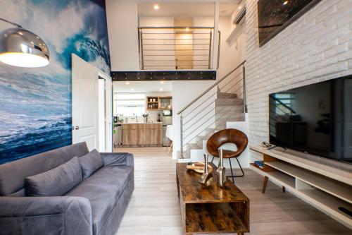 a living room with a couch and a tv at The Lauderdale Boutique Hotel in Fort Lauderdale