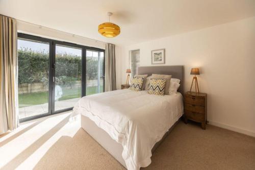 a bedroom with a bed and a large window at Attractive pet friendly beach house in Westward Ho in Westward Ho