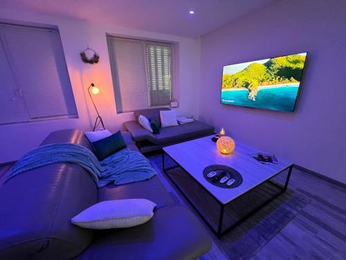 - un salon violet avec un canapé et une table dans l'établissement Nancy Détente Un Séjour à Part, à Nancy