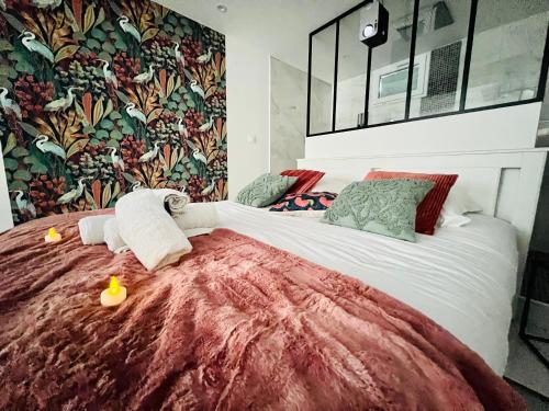 une chambre avec un grand lit avec une couverture rouge dans l'établissement Nancy Détente Un Séjour à Part, à Nancy
