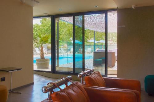 una sala de espera con una piscina vista a través de las ventanas en Hotel Raices Aconcagua en Mendoza