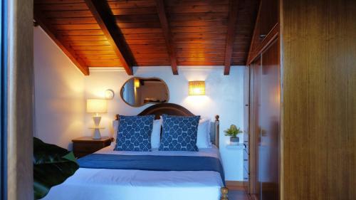 a bedroom with a bed with blue pillows at fantastic holiday house in Ponta Delgada