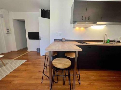 a kitchen with a table and stools in a room at Appartement Climatisé 4 personnes / Centre-ville in Besançon