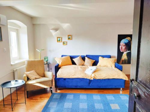 a bedroom with a blue couch and a painting at Stairway to the castle in Ljubljana
