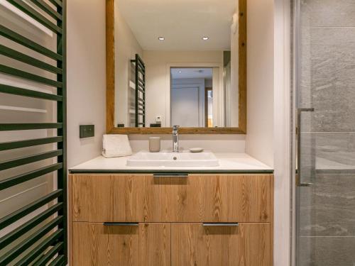 une salle de bain avec un lavabo et un miroir dans l'établissement Cocon intime avec WiFi, garage, et accès direct aux pistes dans résidence neuve à Val d'Isère - FR-1-694-339, à Val dʼIsère
