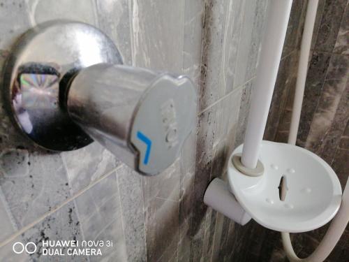 a toilet paper dispenser next to a toilet in a bathroom at Rajarata Lodge in Anuradhapura