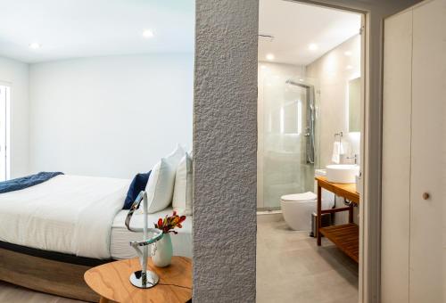 a bedroom with a bed and a bathroom with a shower at The Lauderdale Boutique Hotel in Fort Lauderdale